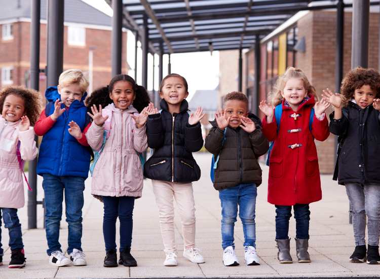 Alcuni bambini fuori da un edificio scolastico - fonte stock.adobe - giornalemotori.it