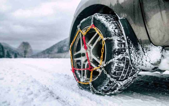 Un'auto con le catene da neve - fonte depositphotos.com - giornalemotori.it