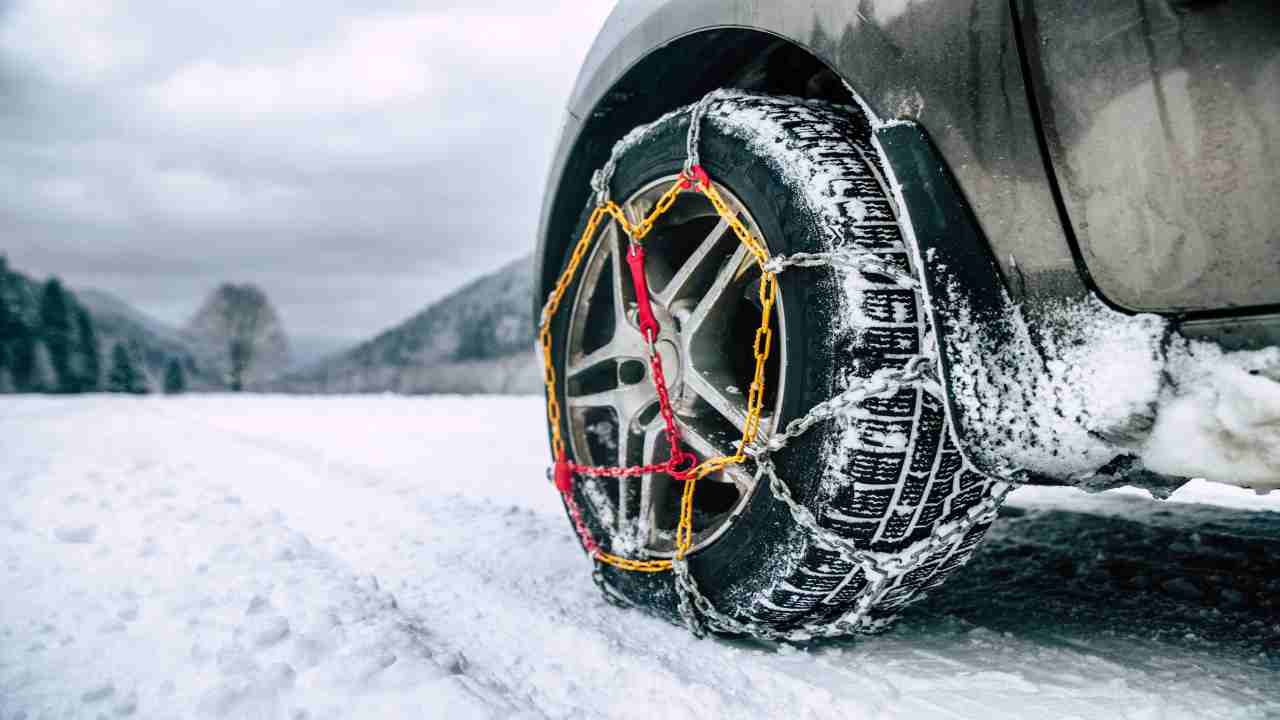 Un'auto con le catene da neve - fonte depositphotos.com - giornalemotori.it